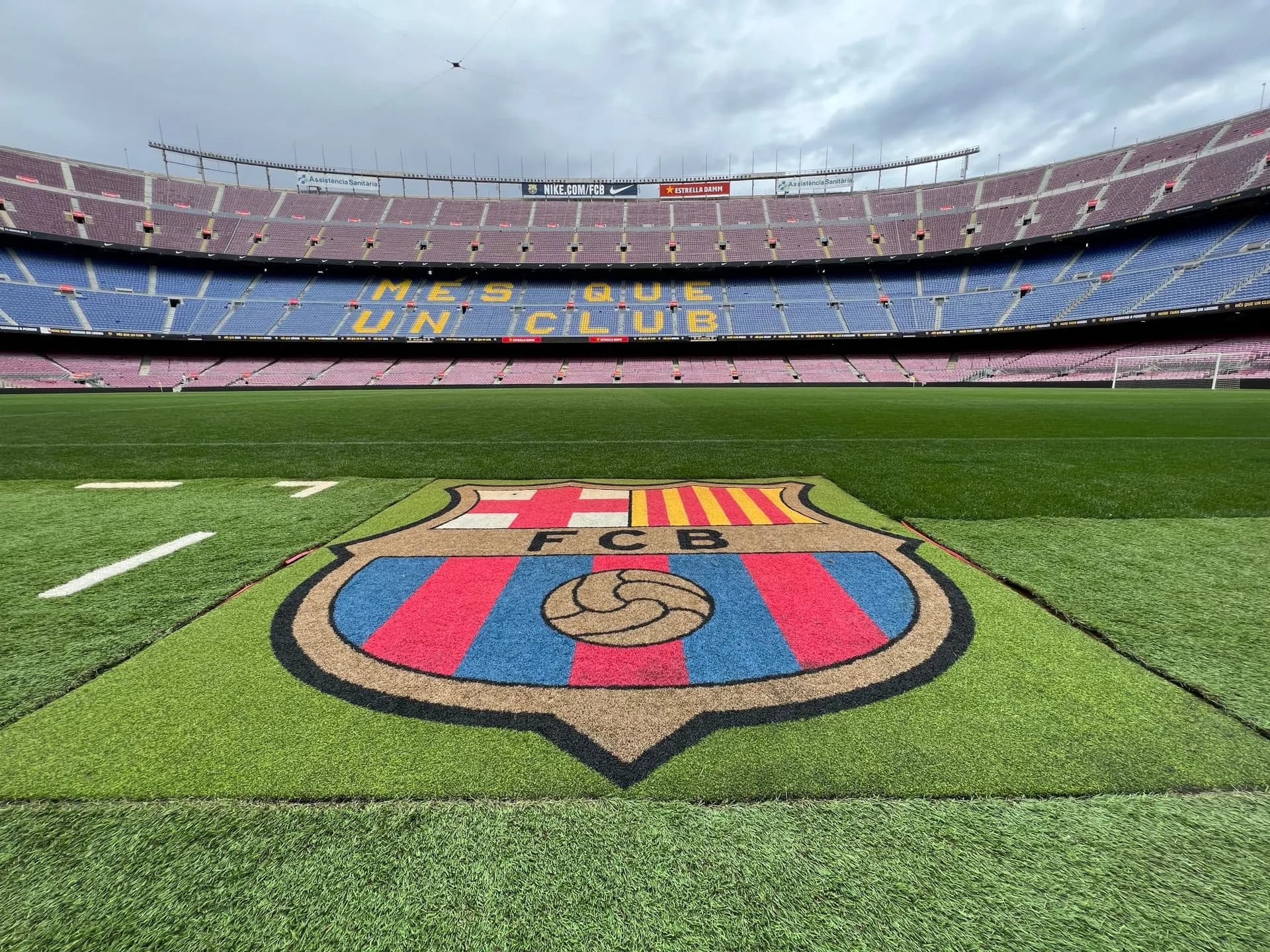 Visitors inside the FC Barcelona Museum Barça Immersive Tour with trophies and a giant club crest display