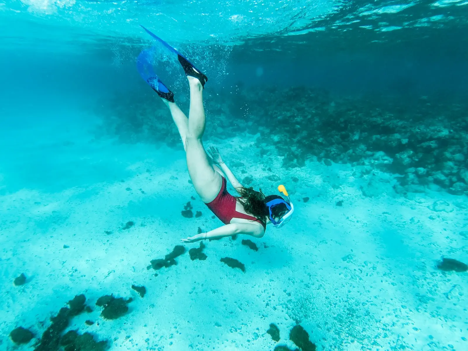 Snorkelers swimming in clear turquoise water beside a sea cave on a Mallorca boat tour