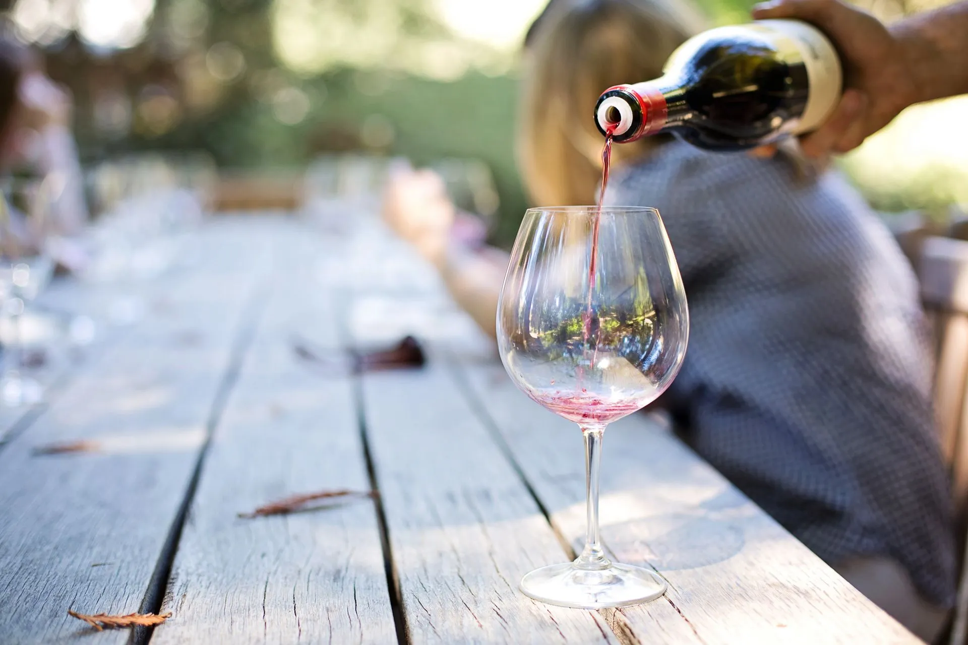 Glasses of red and white Mallorcan wine on a barrel at a vineyard winery with rows of vines behind