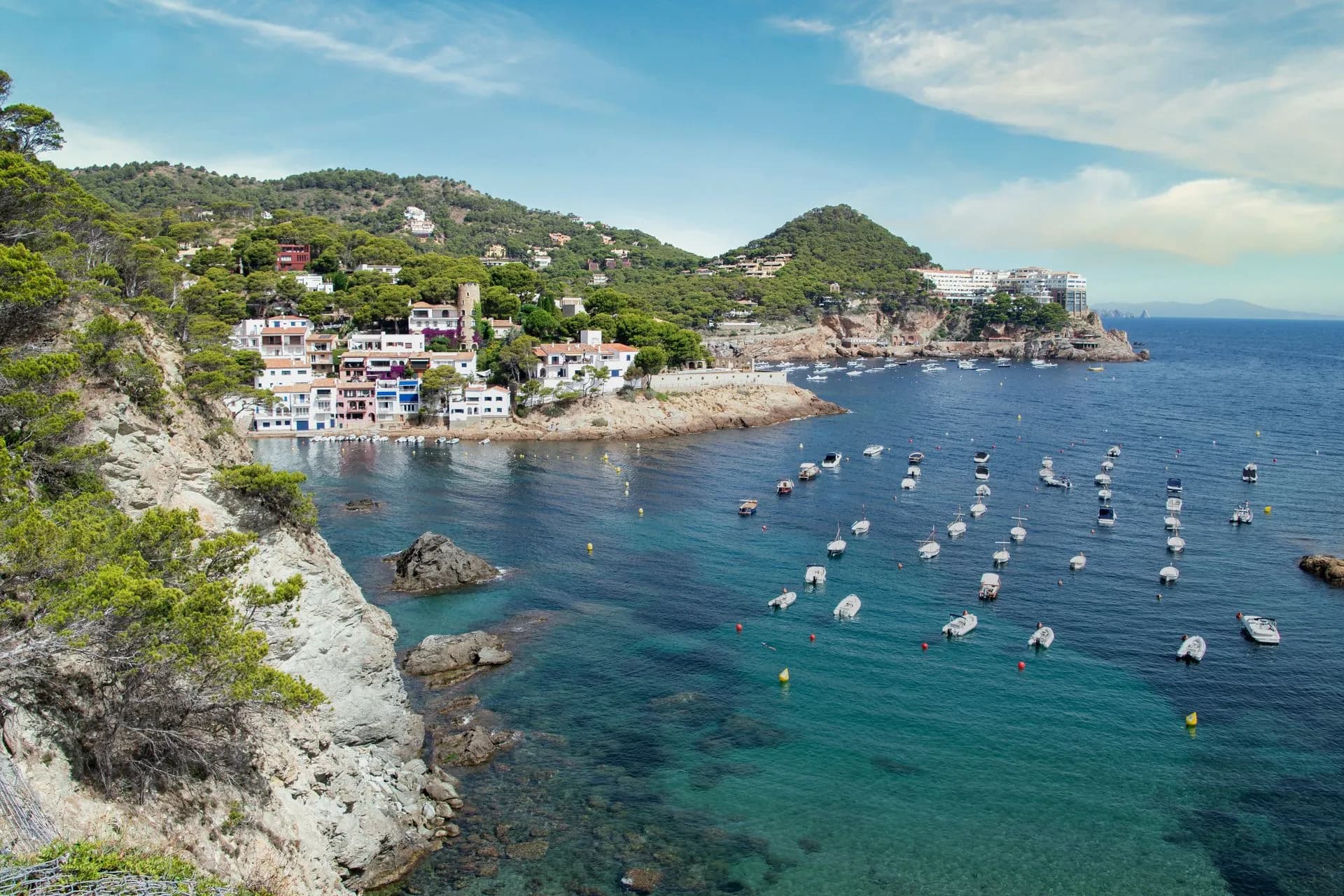 A panoramic boat passing the cliffs of the Costa Brava toward the medieval town of Tossa de Mar