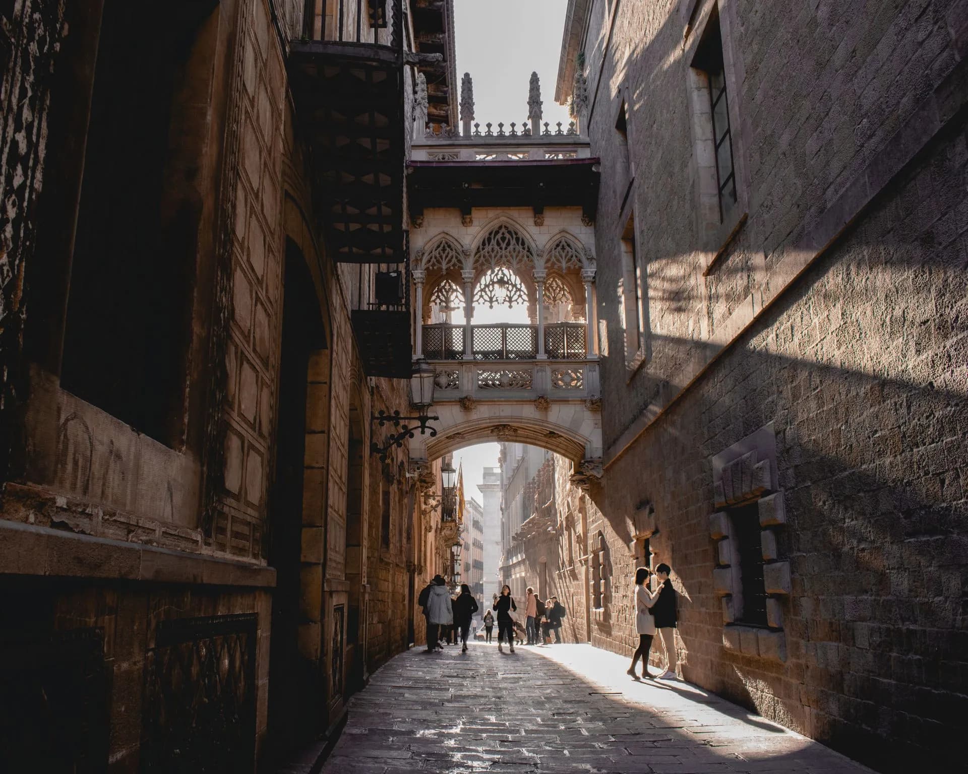 Guide leading a small group through a dark, narrow cobbled street in Barcelona's Gothic Quarter at night