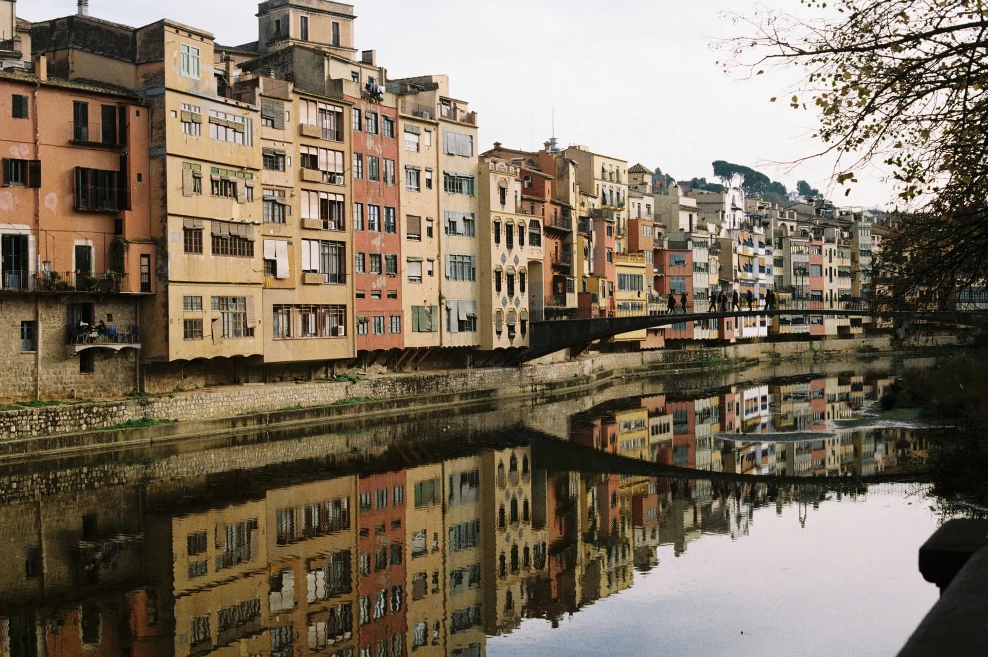 The colorful riverside houses and cathedral of Girona's medieval old town reflected in the Onyar river