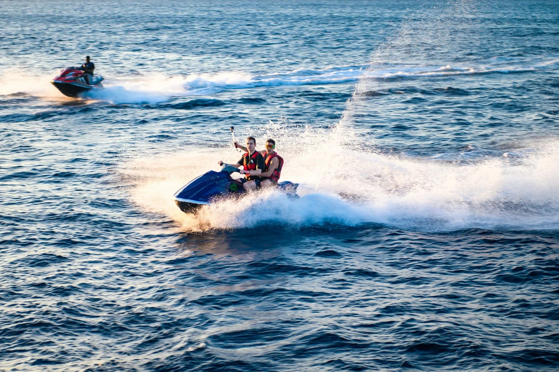 Conductor en una moto de agua a toda velocidad por la costa de Barcelona pasando el perfil de la Barceloneta y el hotel W