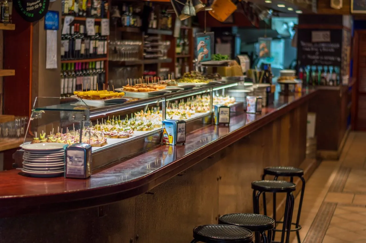 Traditional pintxos and tapas displayed along the bar of a local Spanish tavern in Seville, Spain